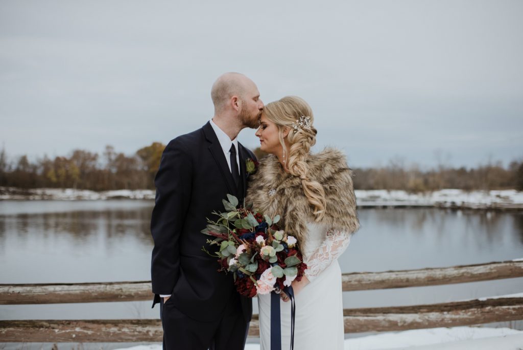 bride and groom embrace outdoors in snowy scene